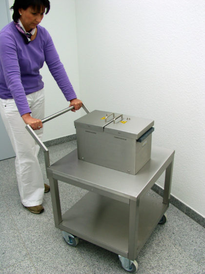 A woman using a lead-shielded laboratory trolley