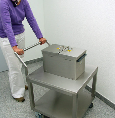 A woman using a lead-shielded laboratory trolley
